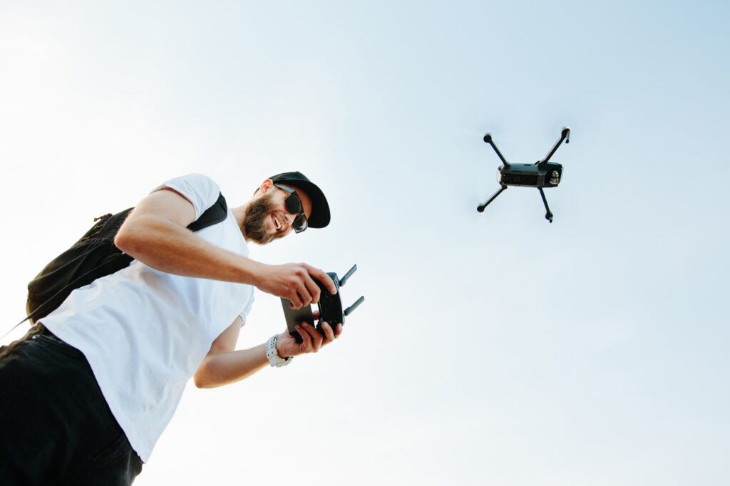 Ragazzo che si diverte guidando drone con controllo remoto, protetto da polizza RC